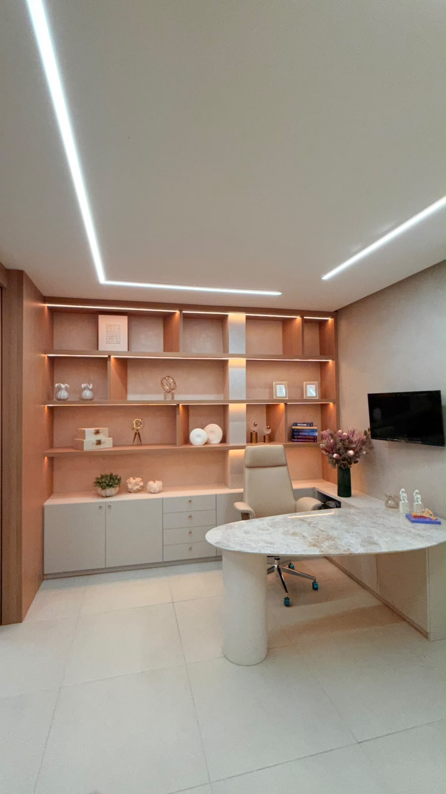 Consultório com mesa curva de mármore e iluminação moderna